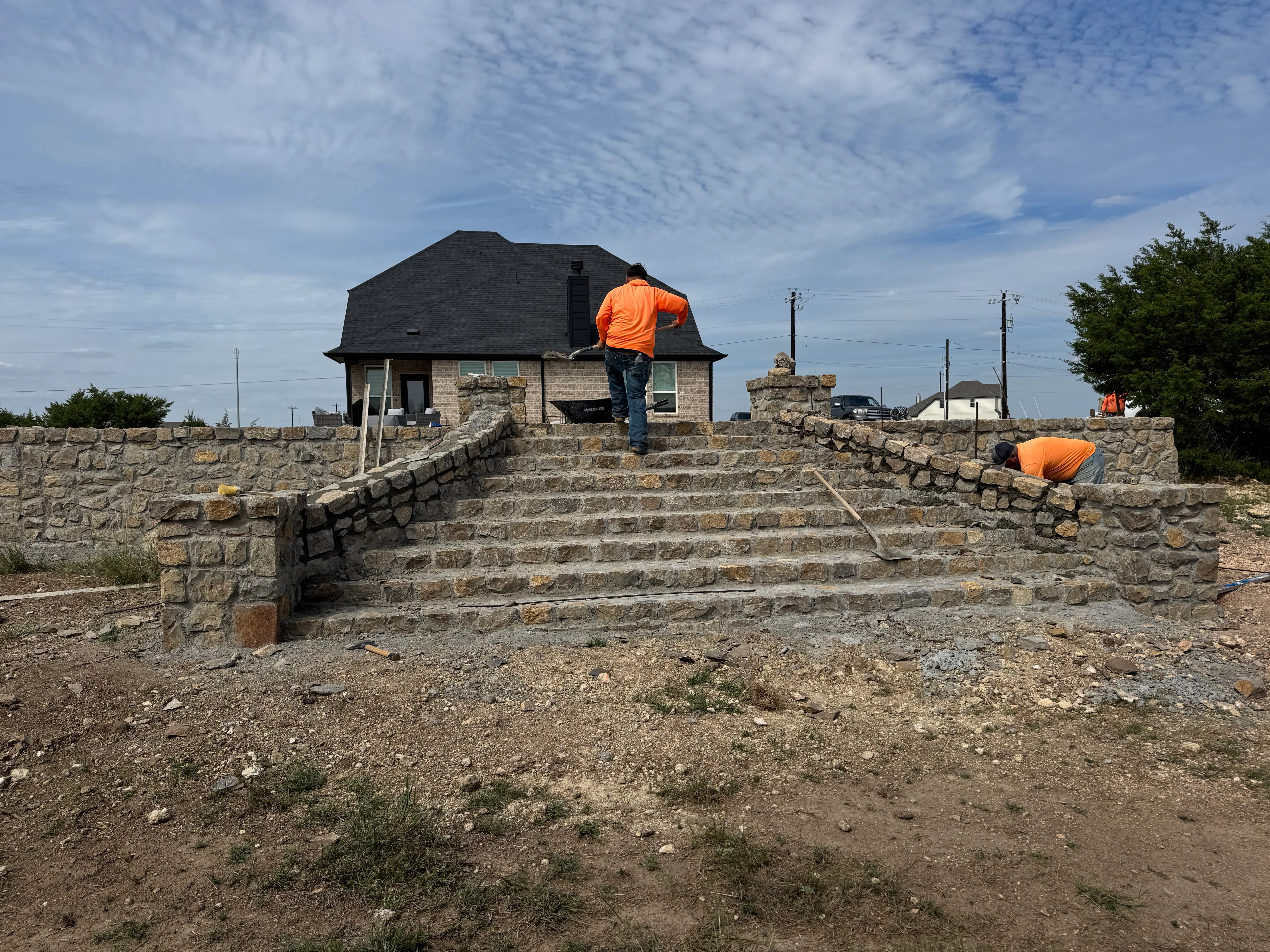 Stone retaining wall with stairway leading to residential home in Weatherford