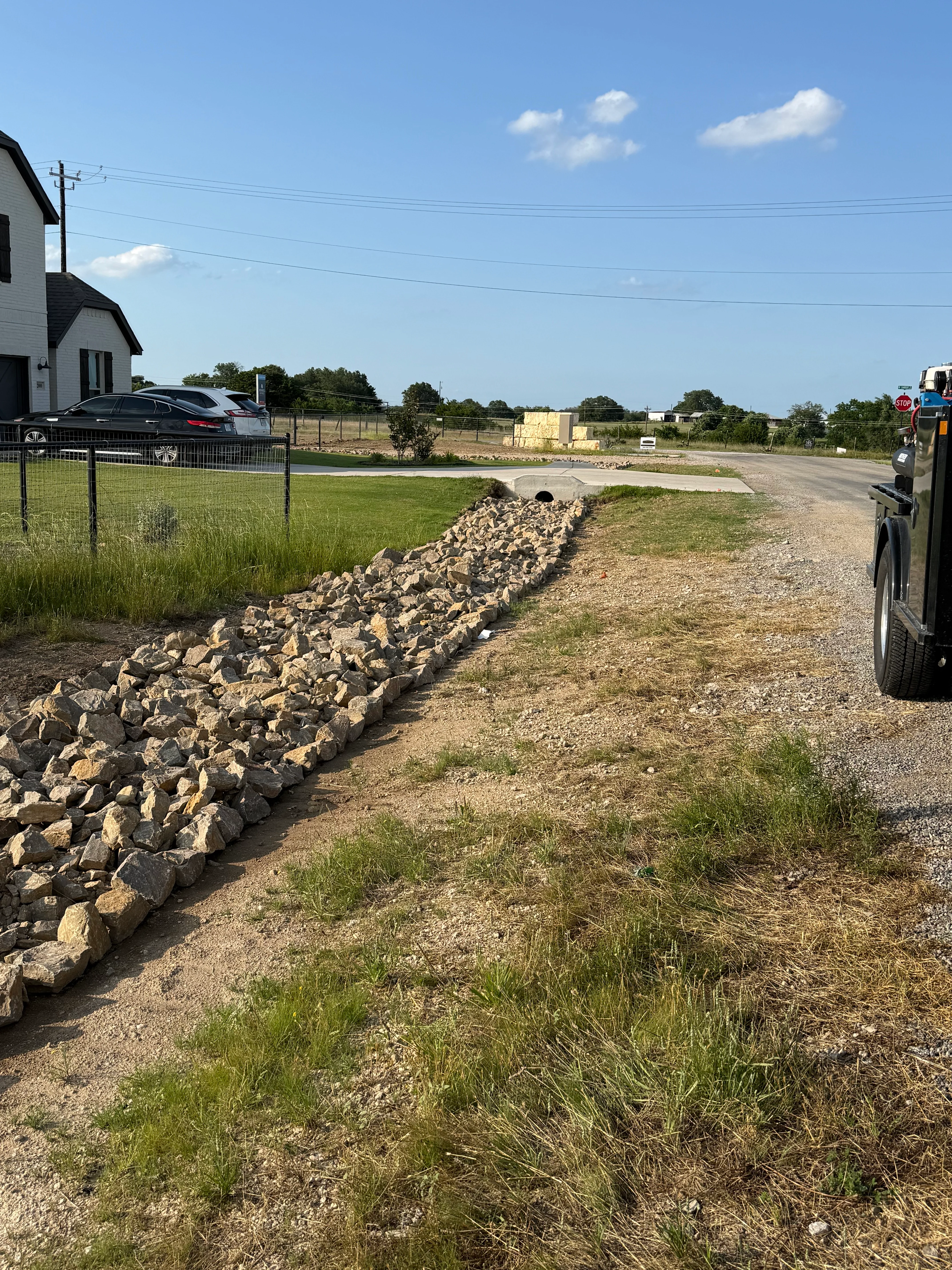 Rock drainage line installation along residential driveway in Weatherford
