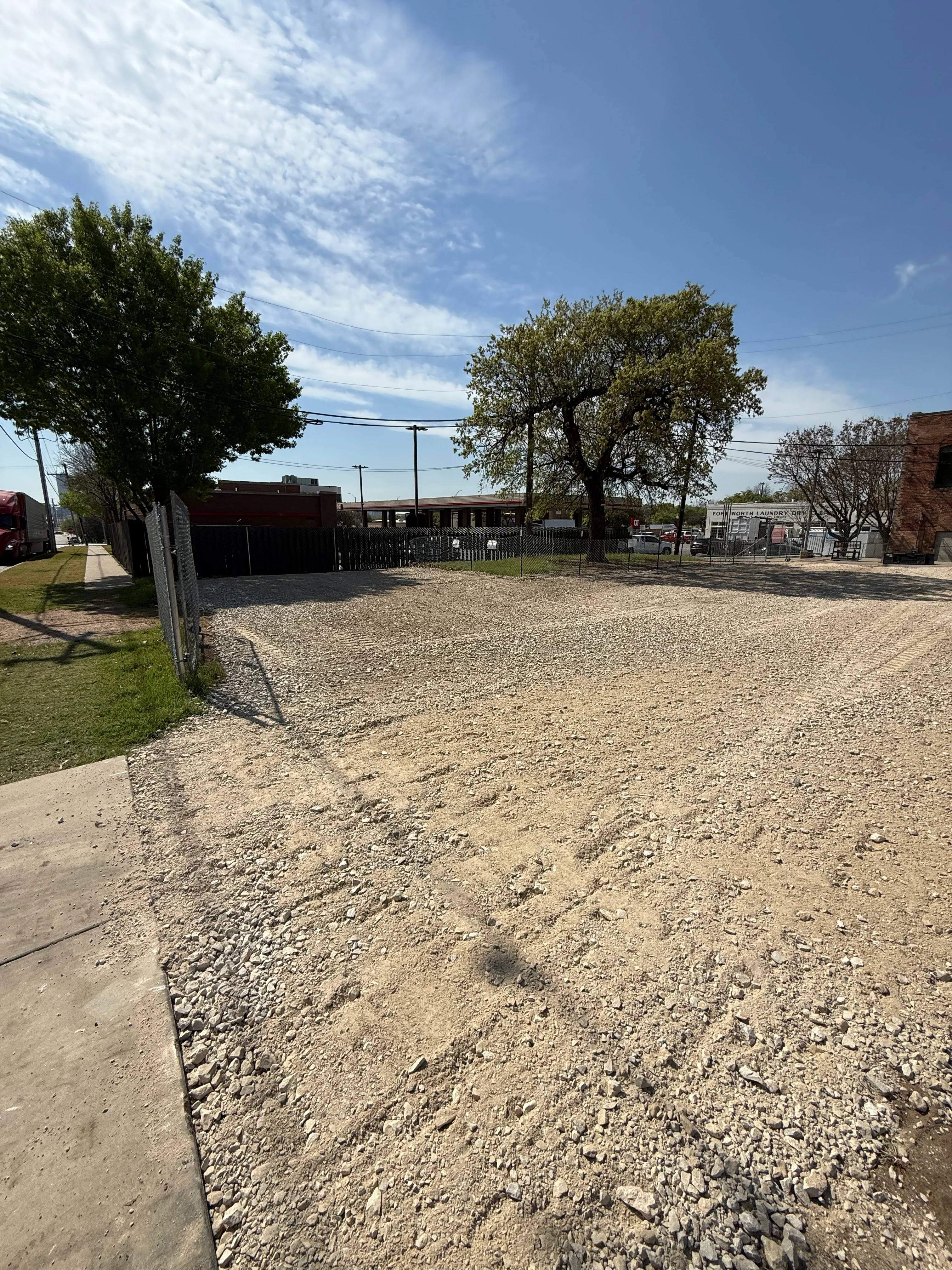 Gravel lot with metal fencing and mature trees in Weatherford, TX