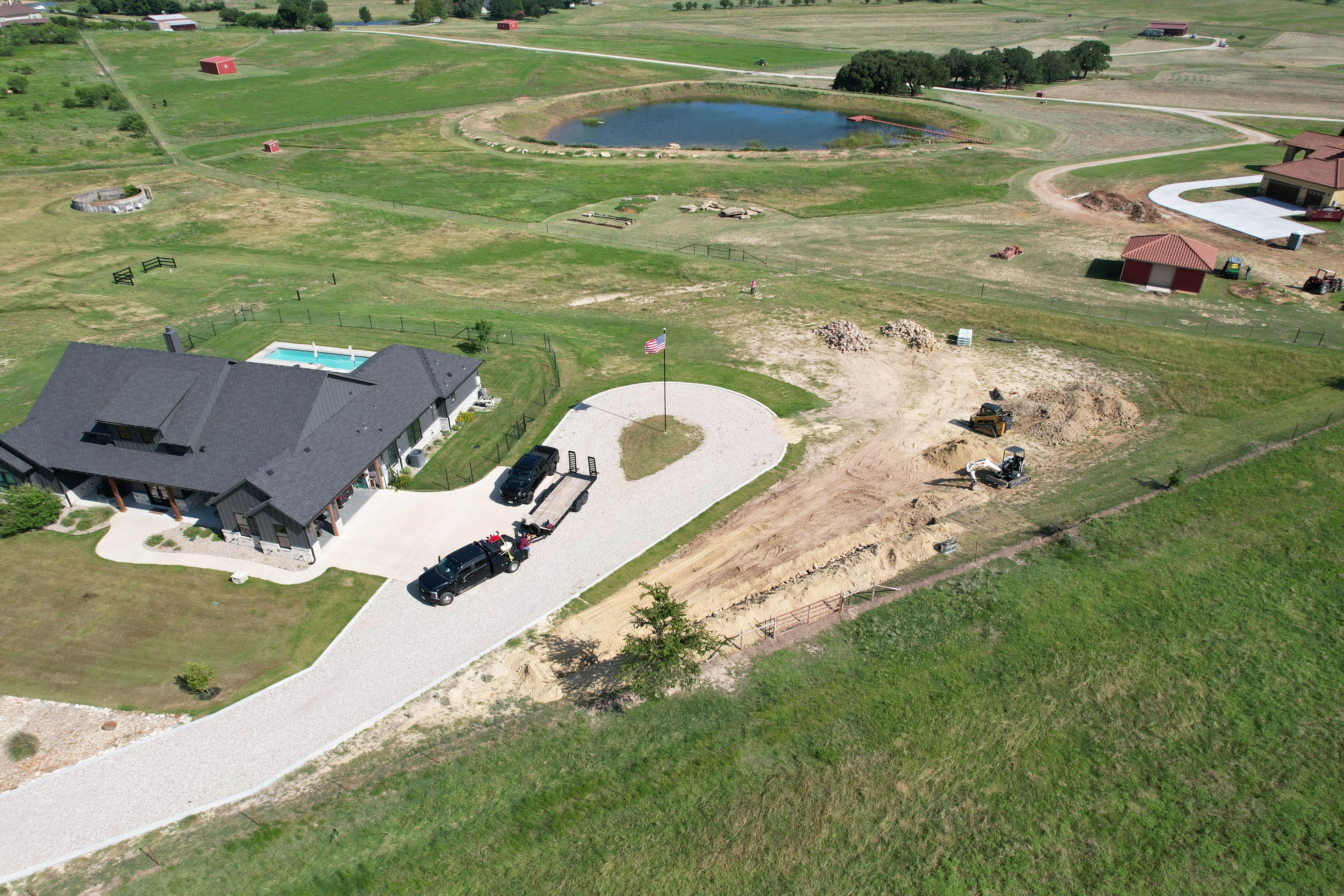 Aerial view of completed concrete driveway with circular turnaround at rural Texas residence